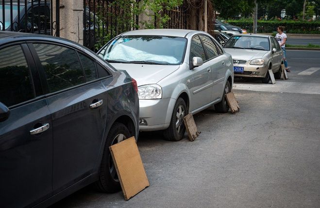 Зачем китайские водители закрывают колеса припаркованных машин фанерой?