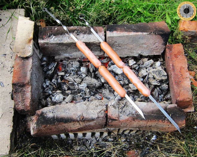 Сосиски обжариваются над горячими углями