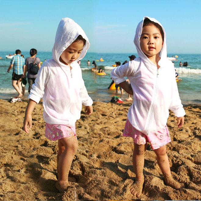 дети в солнцезащитной одежде на пляже